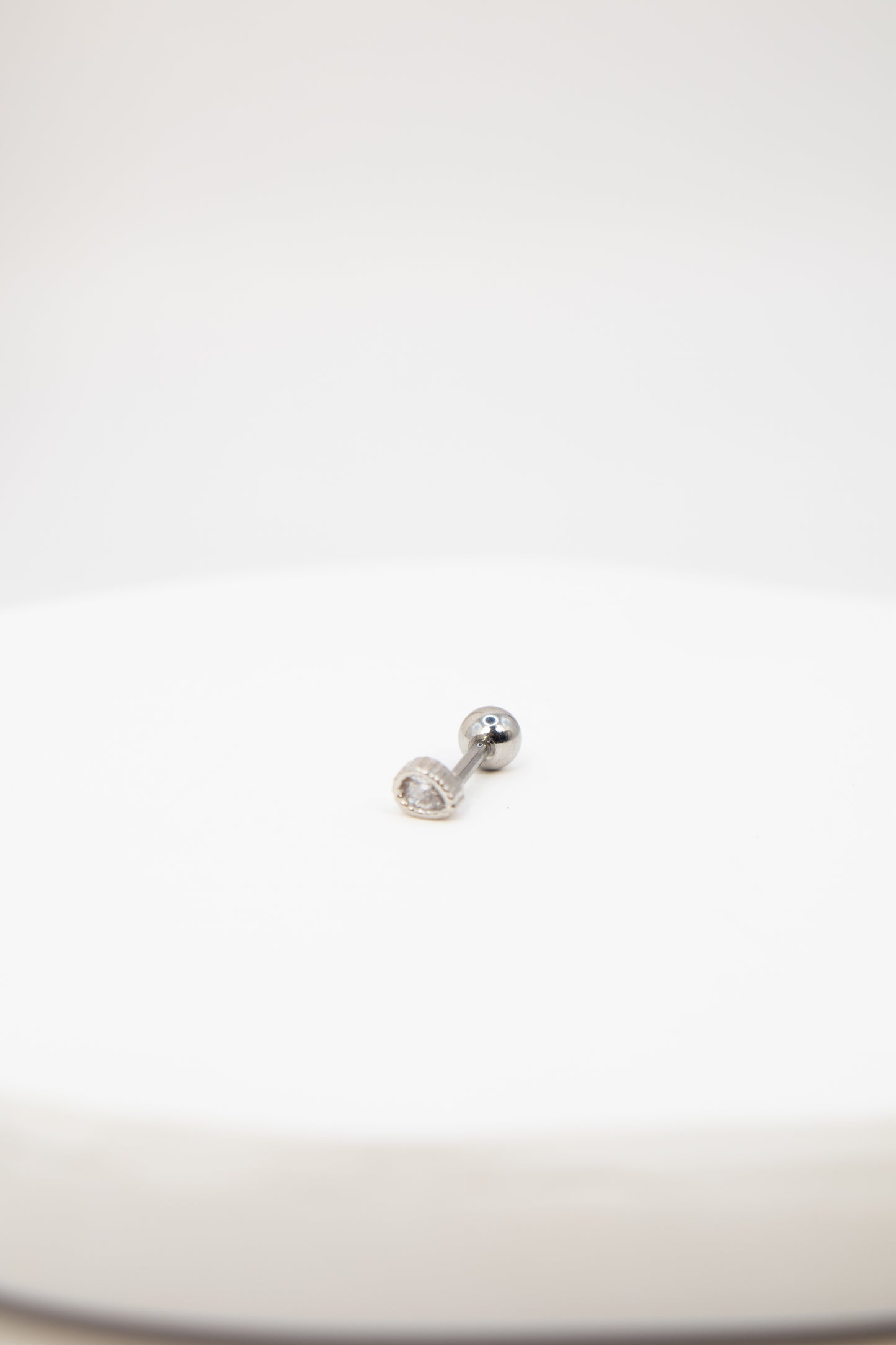 Silver flat back stud earring on a white background