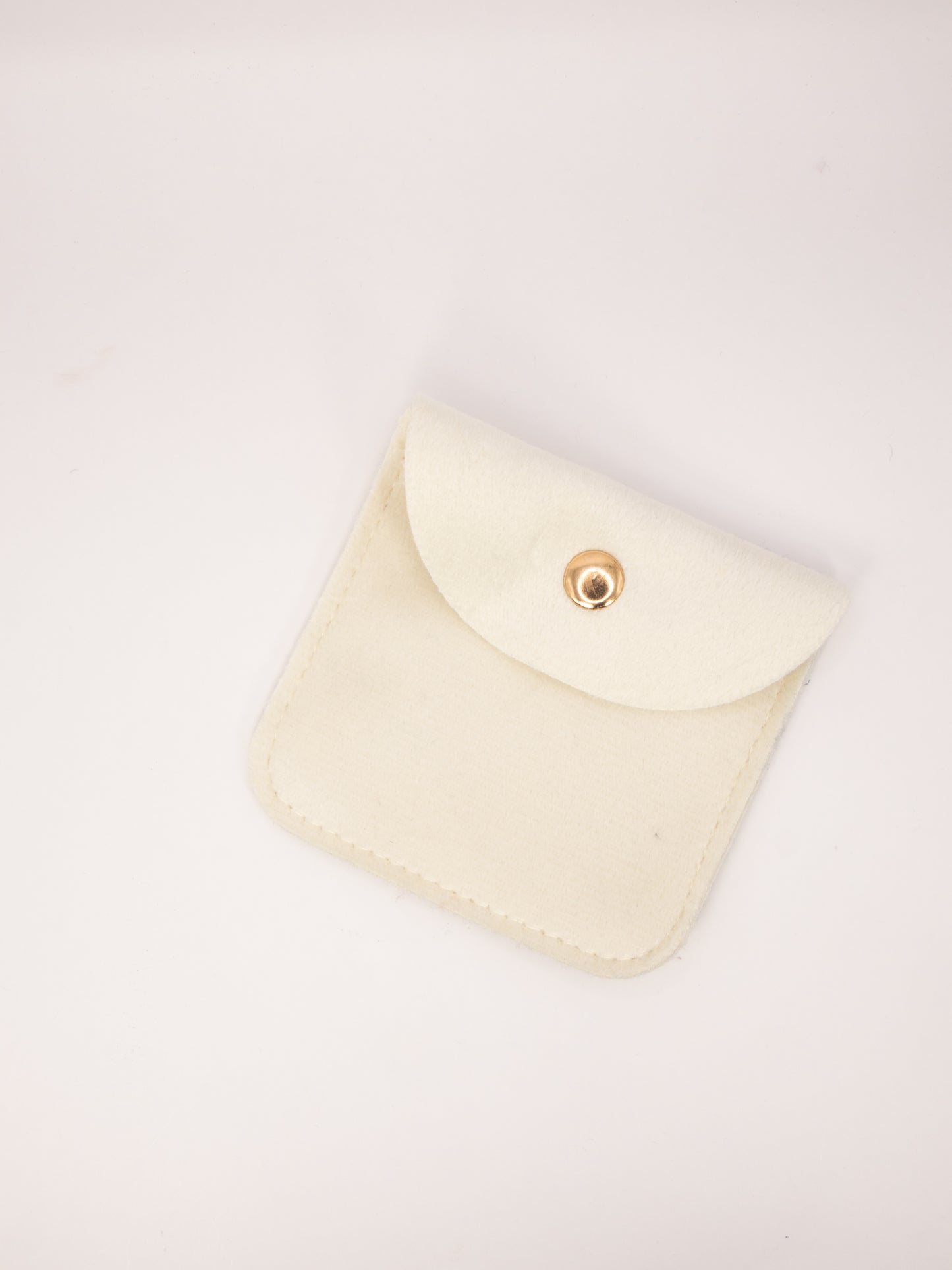 Beige fabric pouch with a gold clasp on a white background