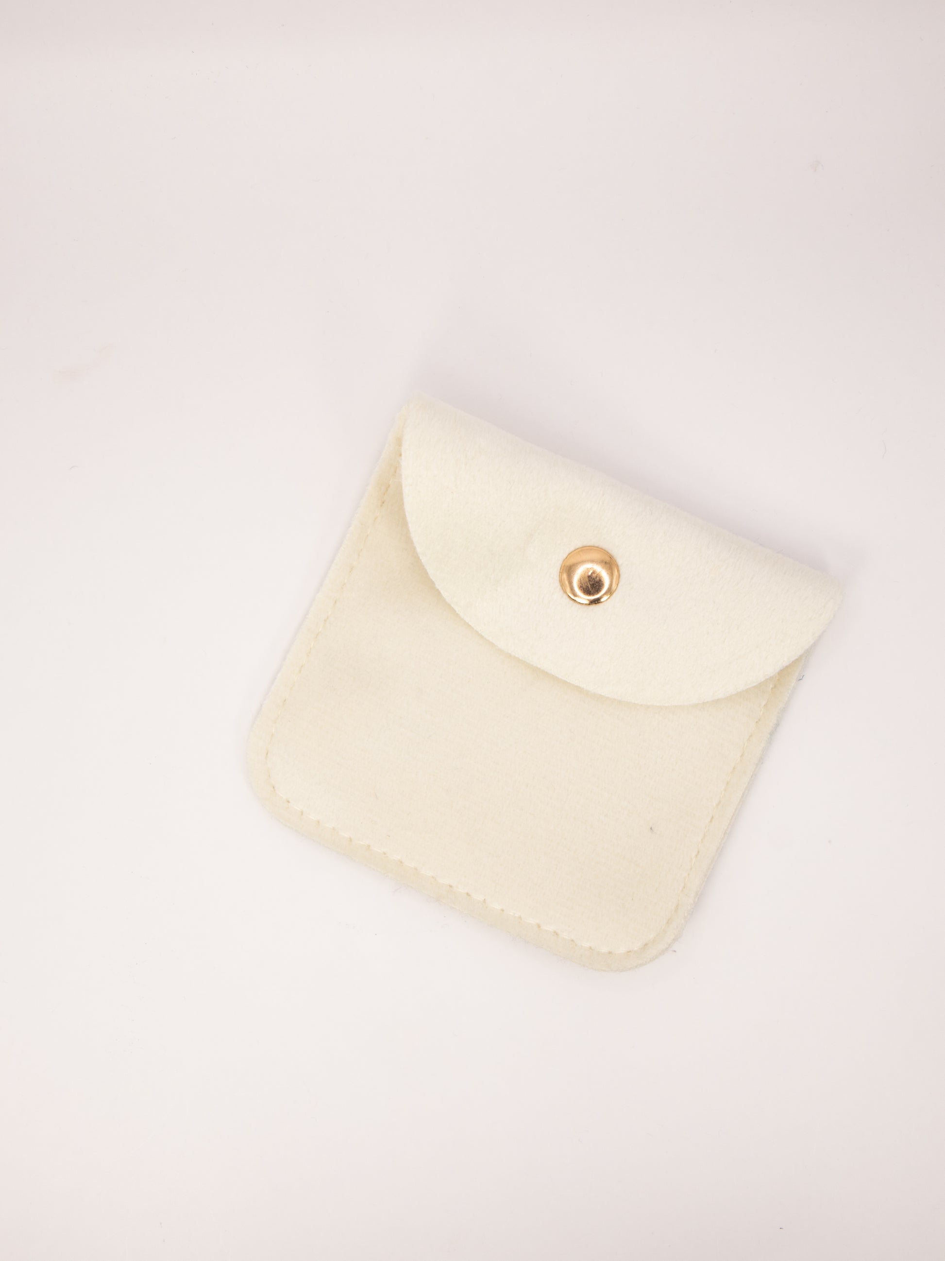 Beige fabric pouch with a gold clasp on a white background