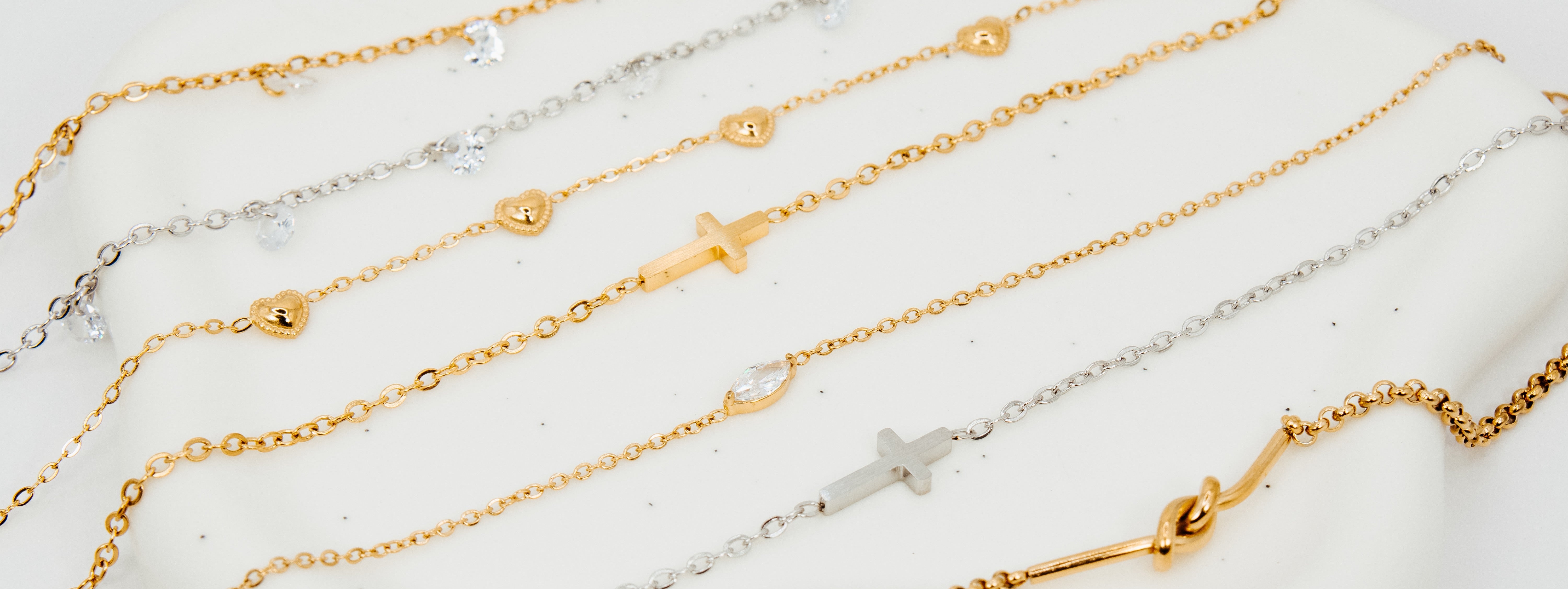 Gold and silver bracelets on a white surface