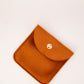 Small orange pouch with a button on a white background