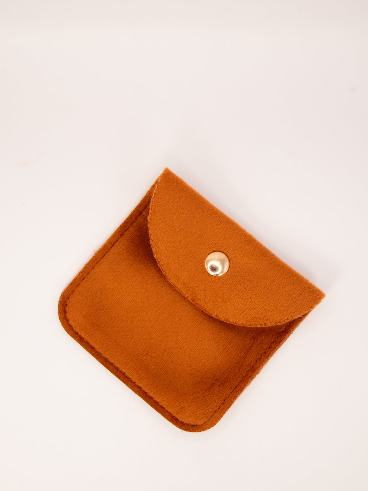 Small orange pouch with a button on a white background