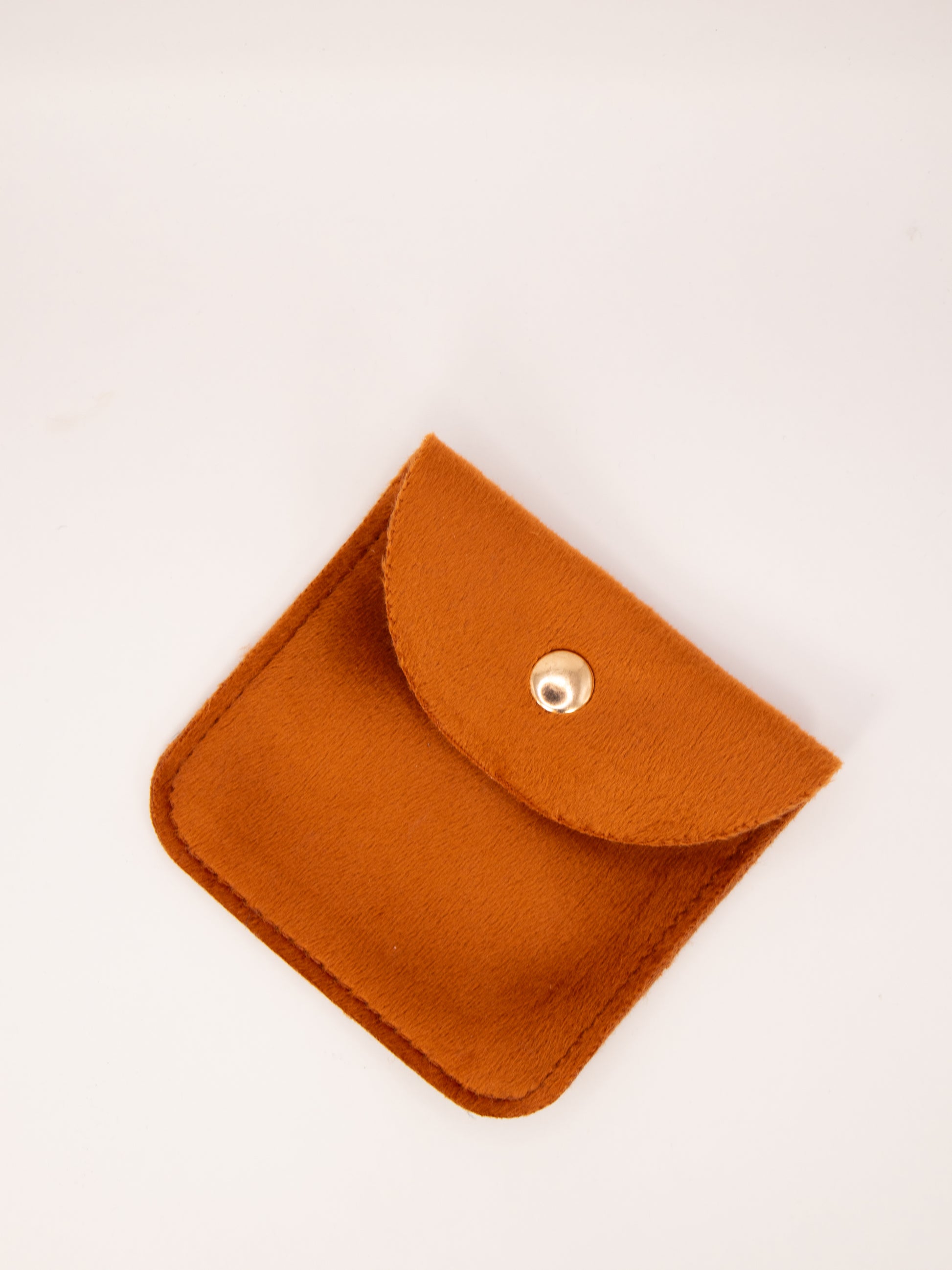 Small orange pouch with a button on a white background