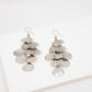 Pair of silver leaf-shaped earrings on a white background