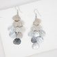 Pair of layered tassel earrings on a white surface