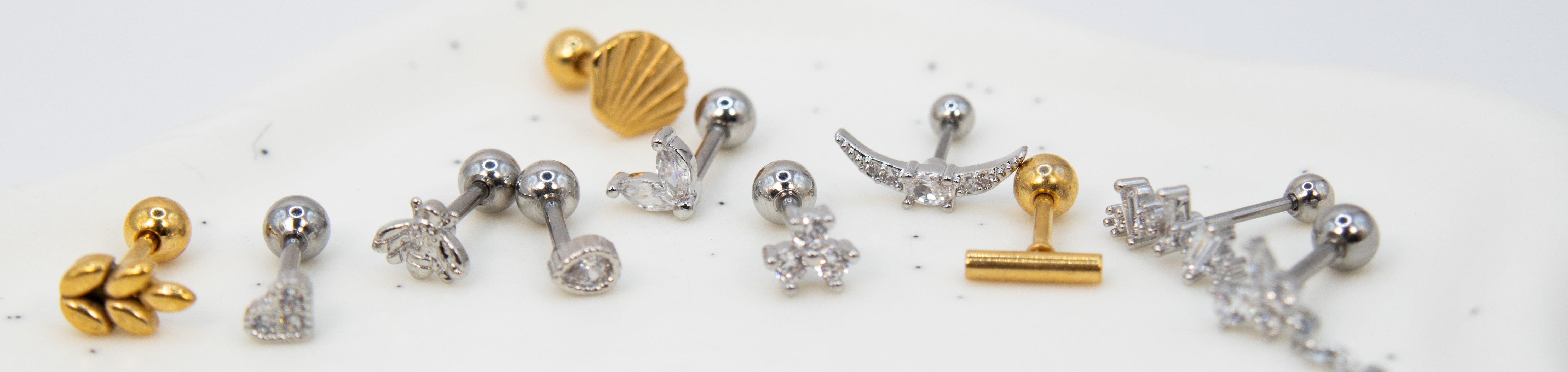 Collection of gold, silver, and crystal earrings on a white background