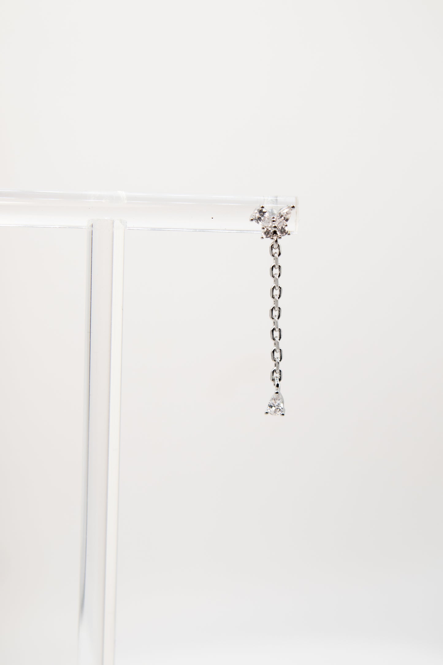 Silver chain earring with crystals on a white background