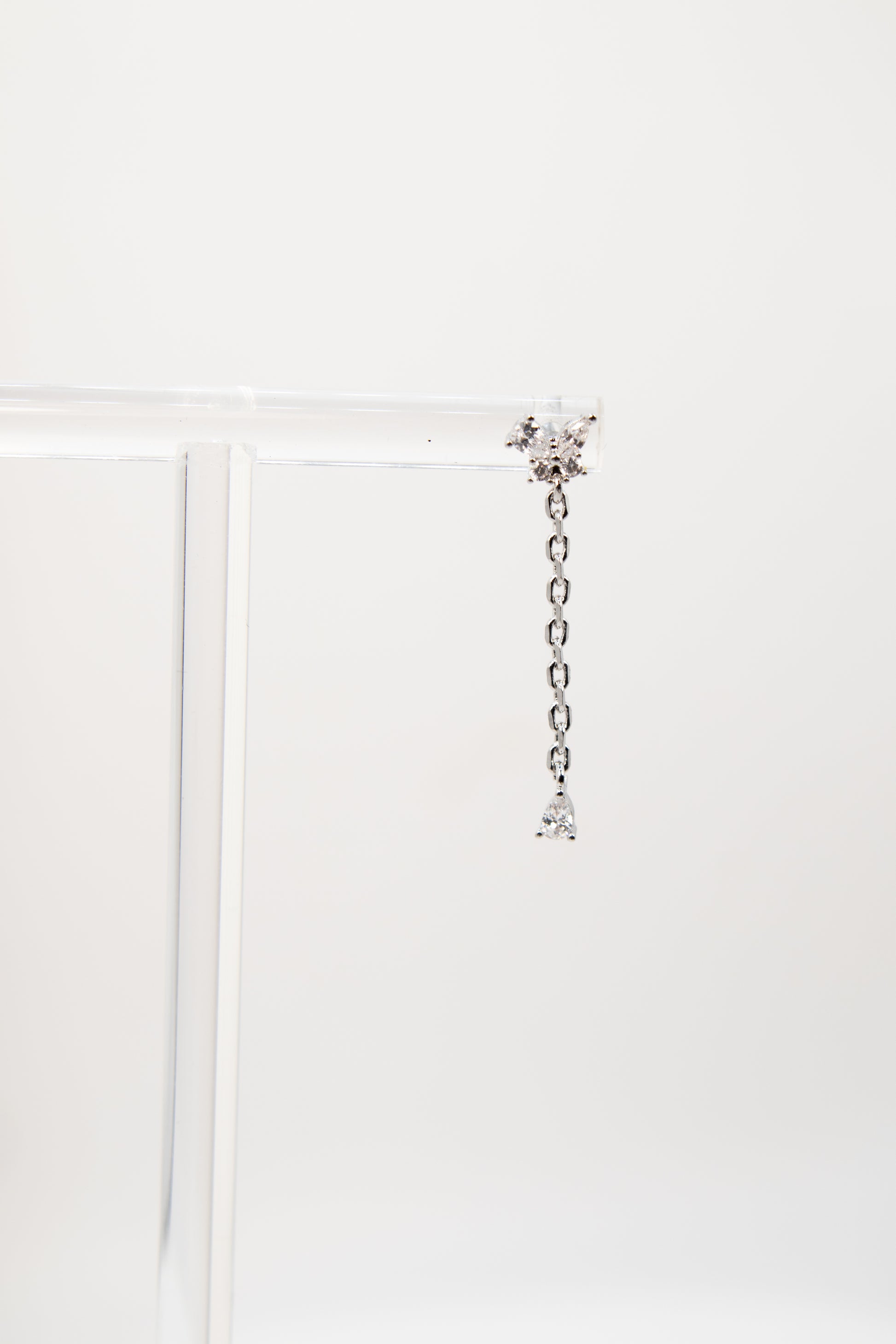Silver chain earring with crystals on a white background