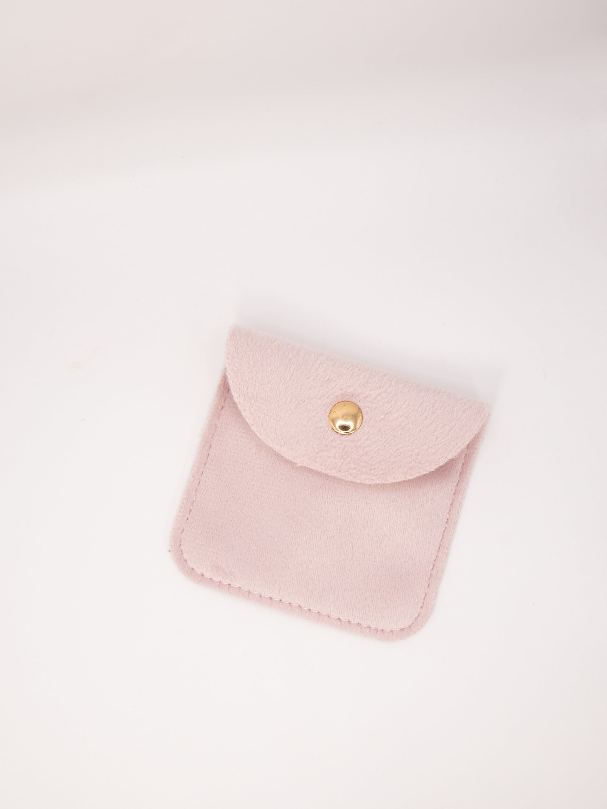 Pink suede pouch with a gold clasp on a white background