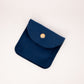 Navy blue pouch with a gold button on a light beige background
