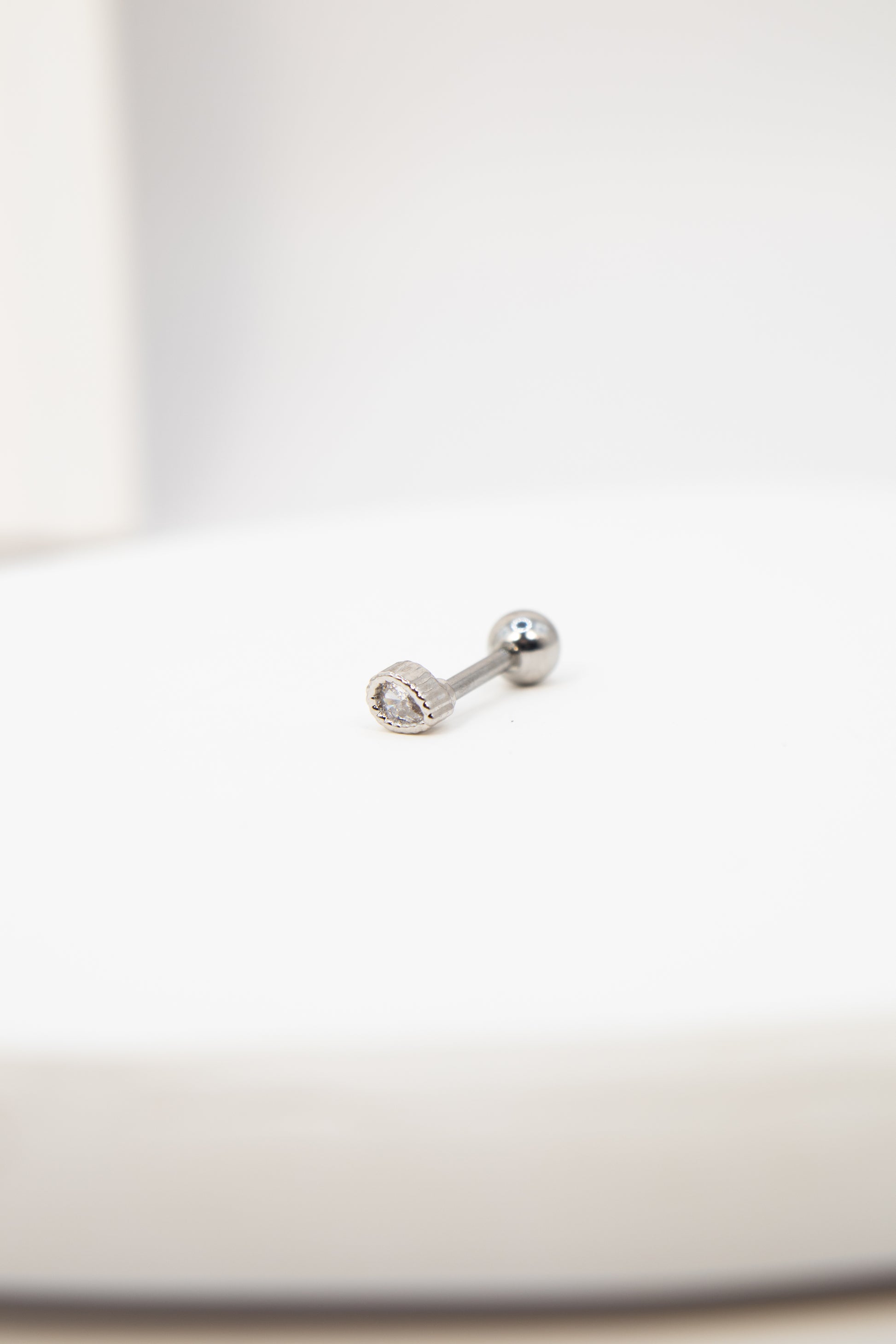 Silver flat back stud earring on a white background